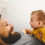 Father and baby daughter playing together family home lifestyle dad and child parenthood love emotions concept
