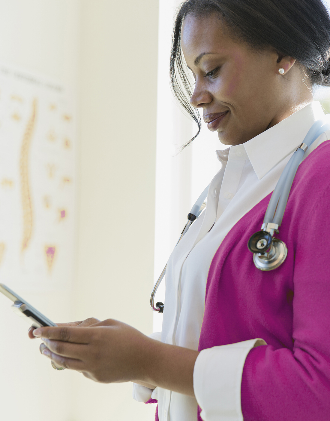 Female doctor looking at mobile phone in clinic