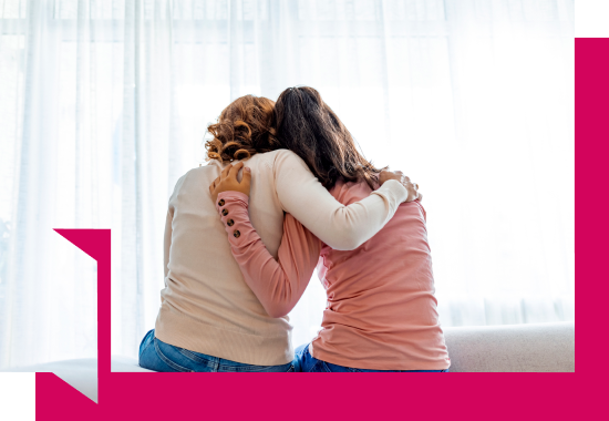 A woman giving her friend a side hug A woman giving her friend a side hug